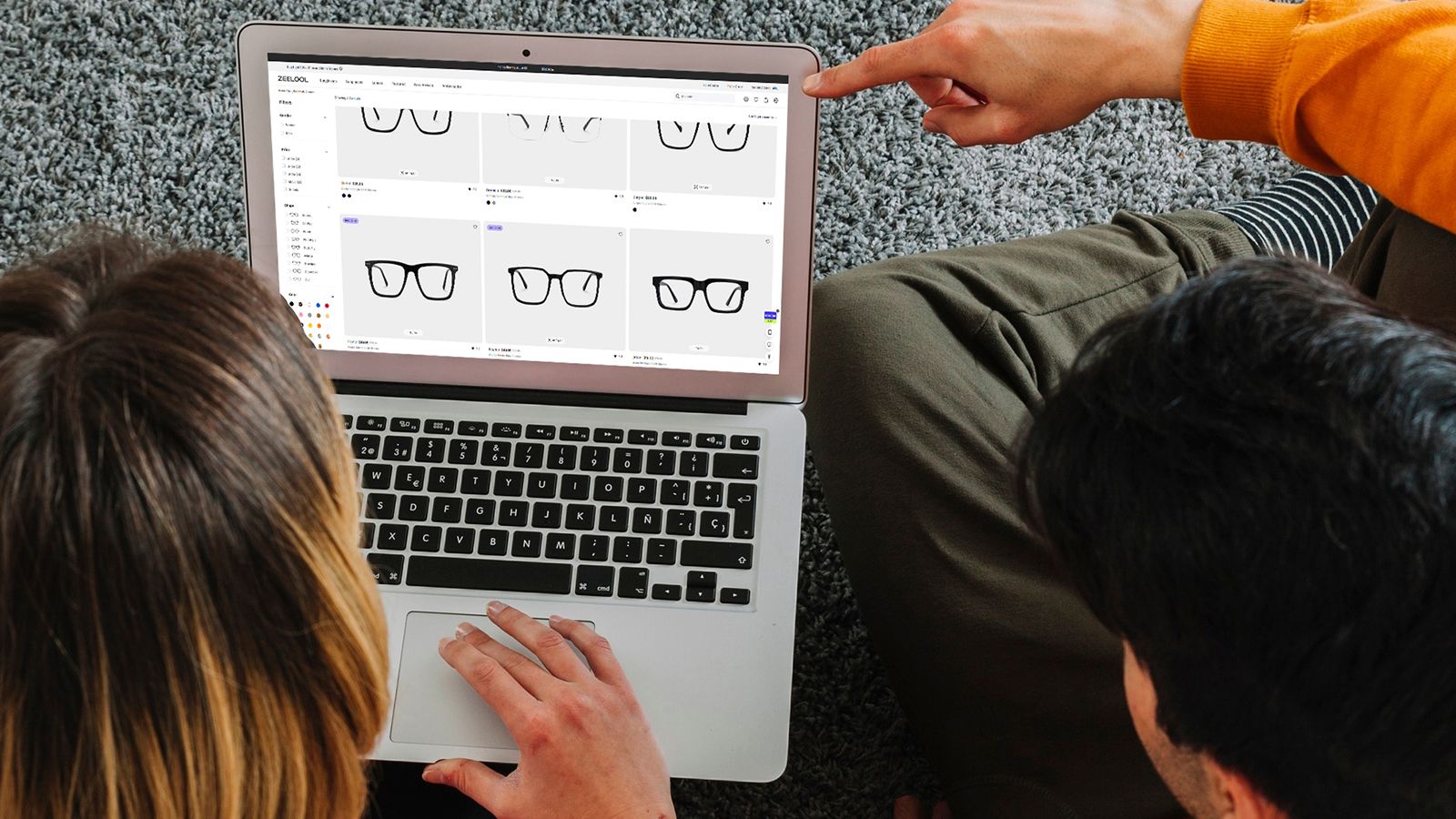 Two people browsing stylish eyewear frames on the SatisVision website via laptop.