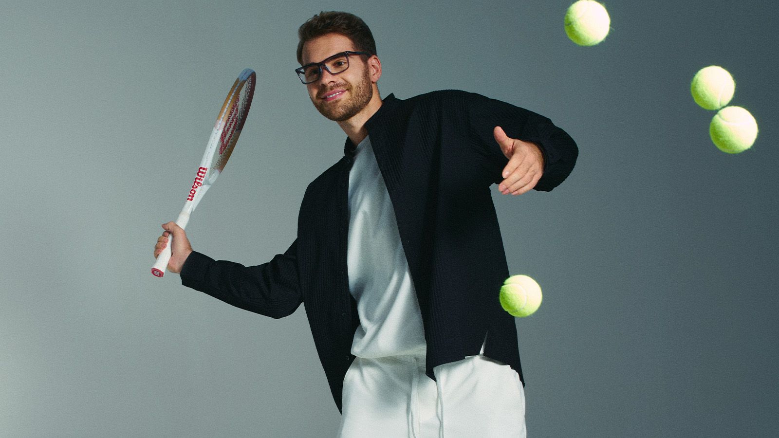 Man playing tennis wearing lightweight injection plastic eyeglasses, ideal for active lifestyles and flexibility.
