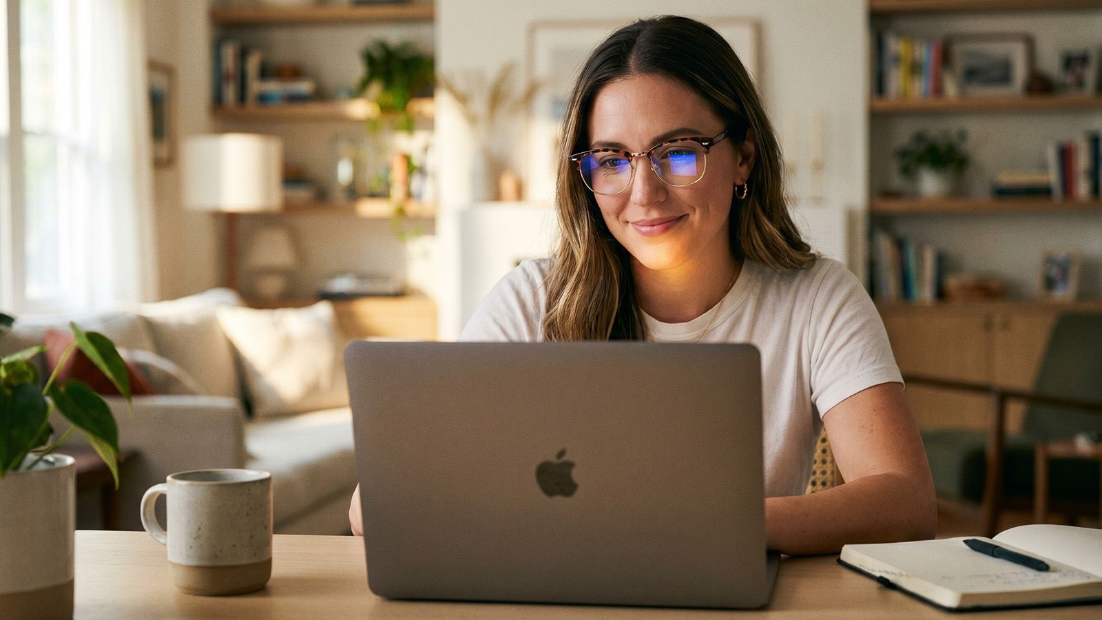 A woman wearing blue light blocking frame glasses working at laptop